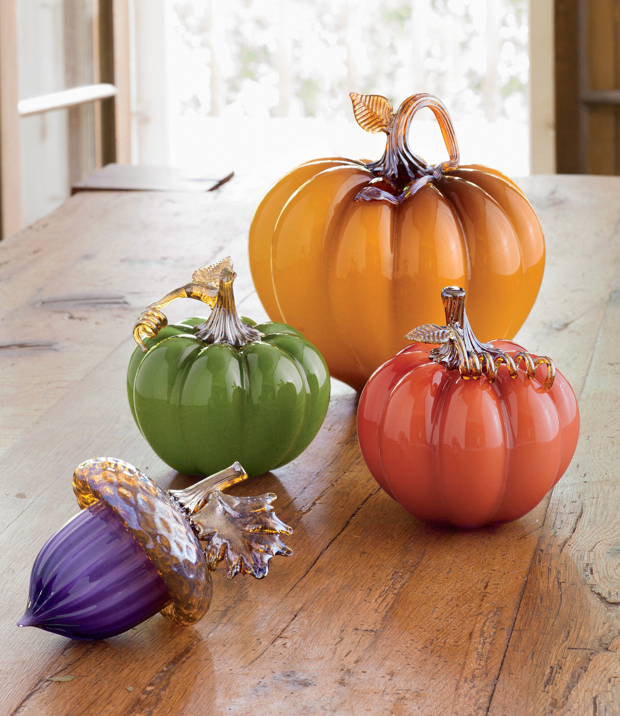clockwise from top: large persimmon pumpkin, medium mandarin pumpkin, hyacinth forest acorn, and medium sweet pea pumpkin