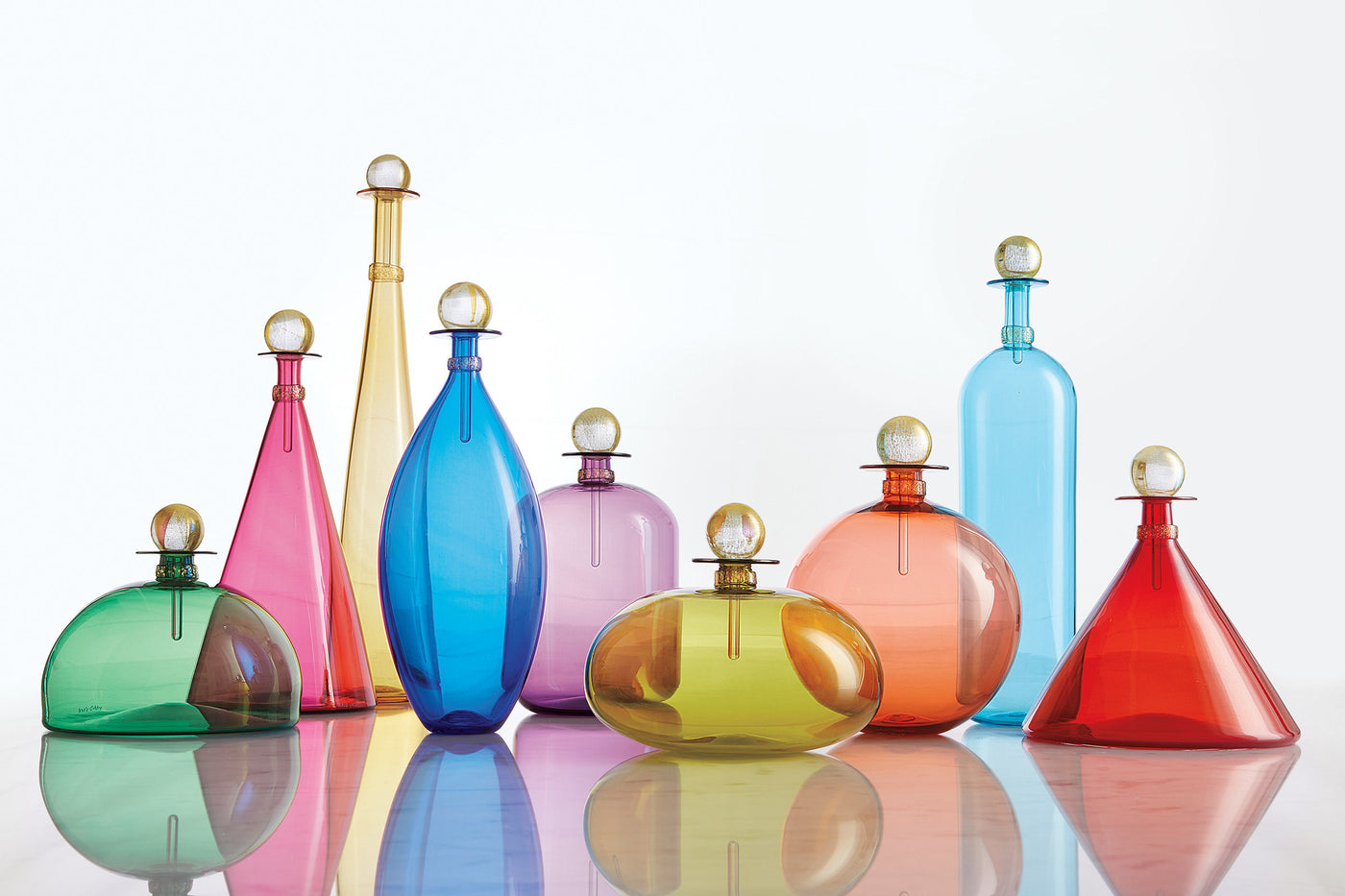 left to right: emerald green dome, medium ruby cone, Tall Topaz Cone, Cerulean Ellipse, amethyst jug, olive squat orb, apricot sphere, Tall Copper Blue Bottle, short cherry red cone