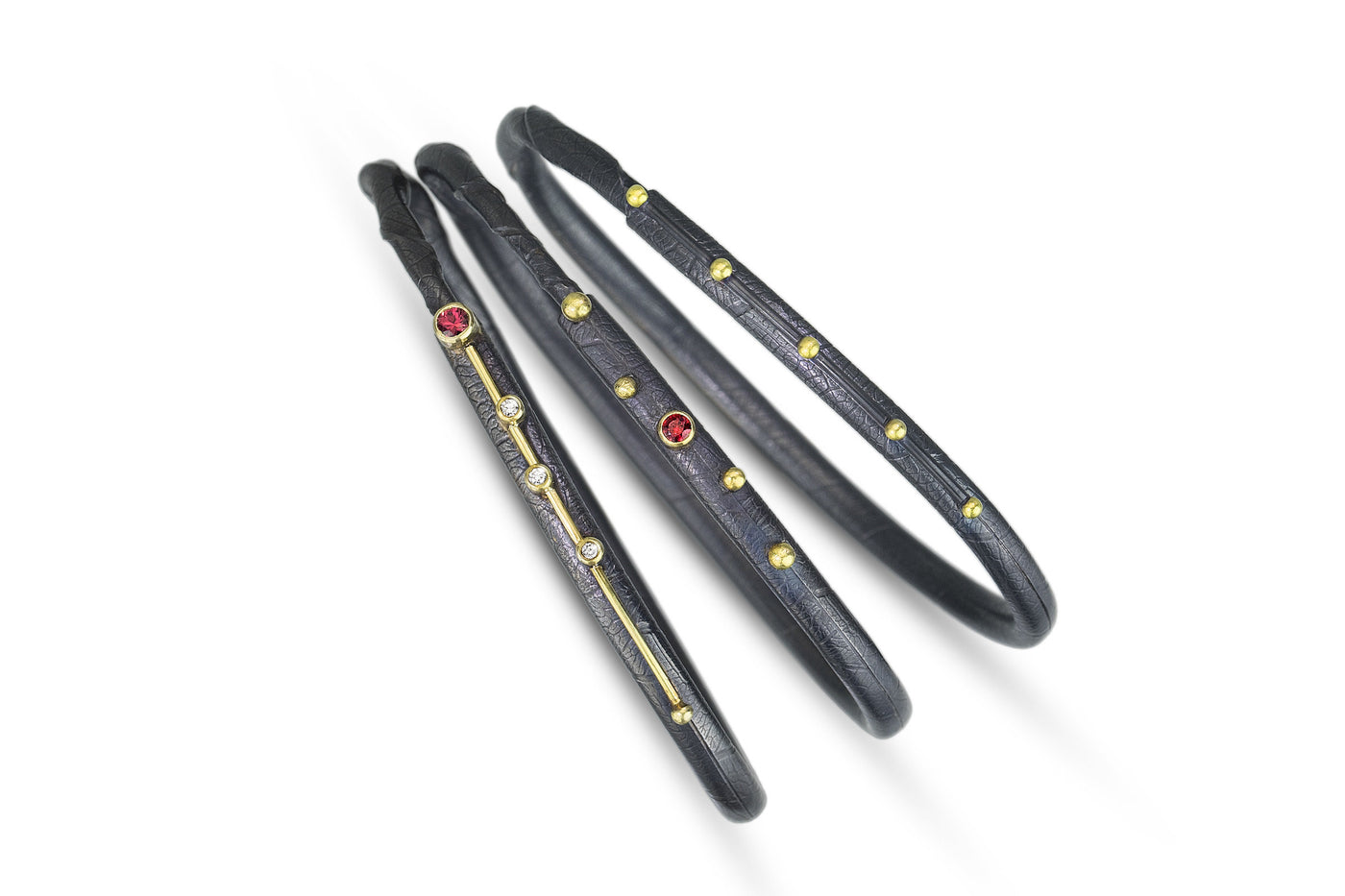 left to right: red sapphire and diamond punctuated line, red sapphire, punctuated line