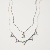 shown with the artist's Small Moon Pendant