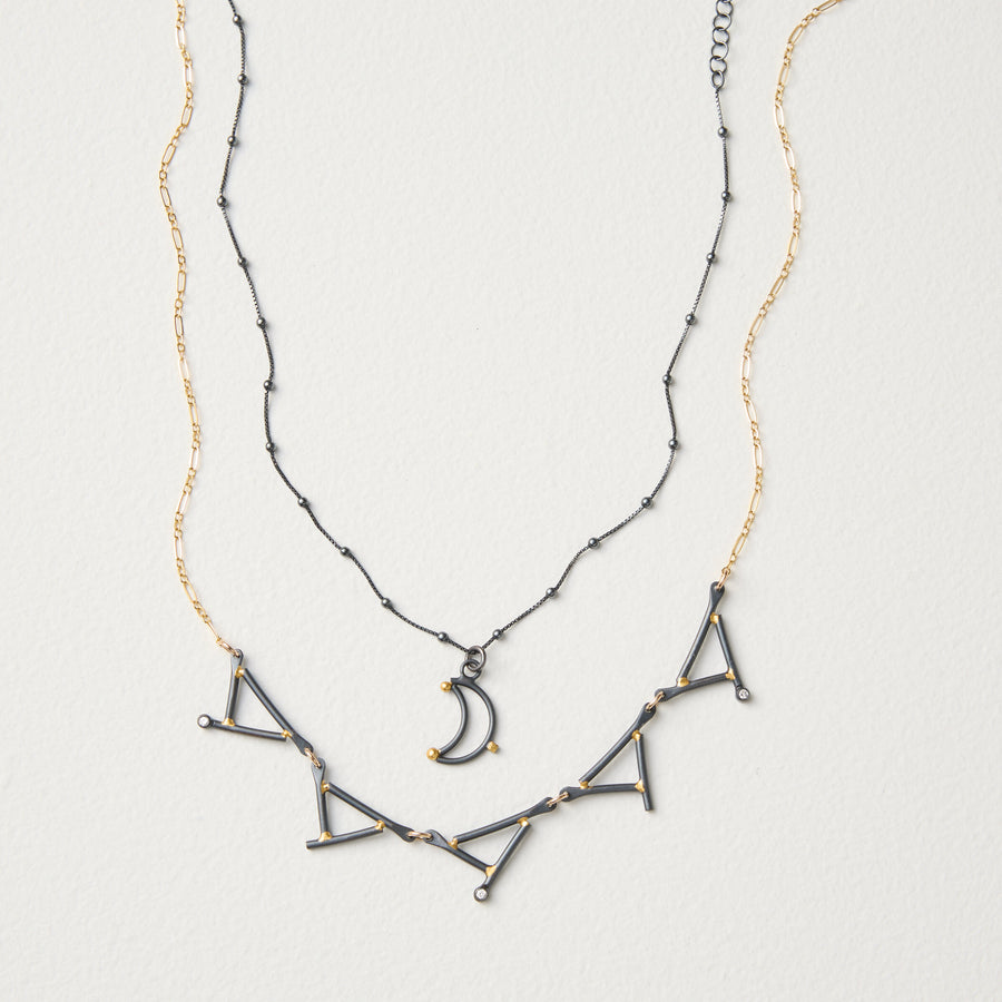 shown with the artist's Small Moon Pendant