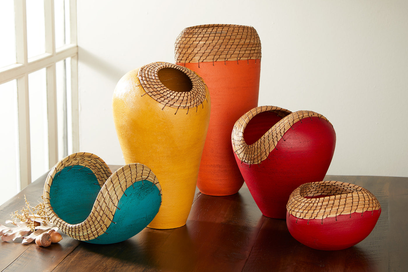 left to right: small boat in teal, ochre nest, oval vessel in orange, medium red heart, triangle bowl in red
