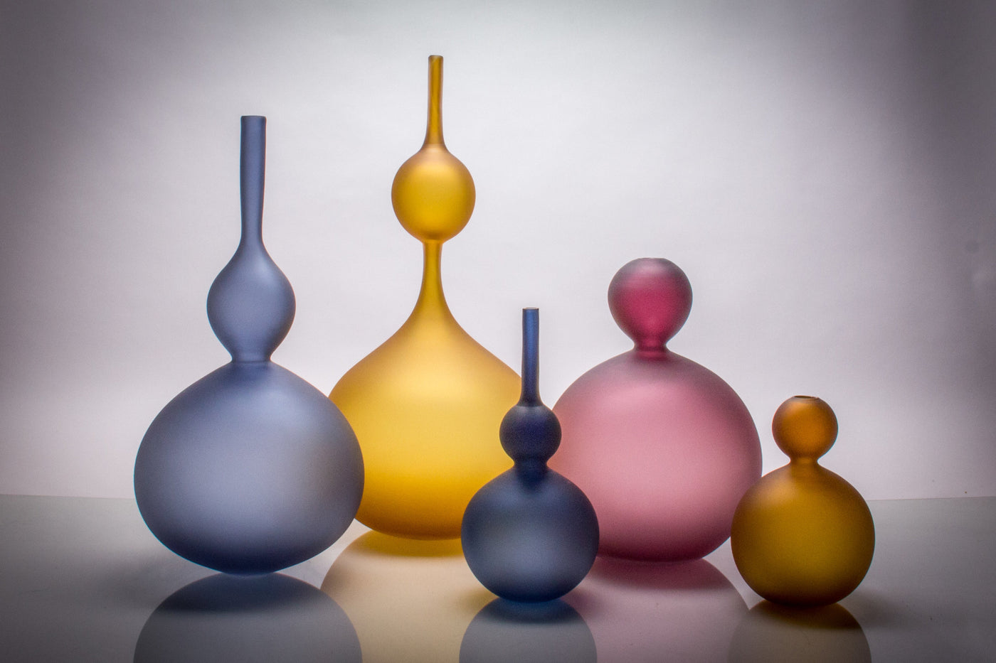 left to right: Large Midnight Perle Bottle, Amber Perle Double Bottle, Small Midnight Perle Bottle, Large Purple Perle, Small Burnt Amber Perle