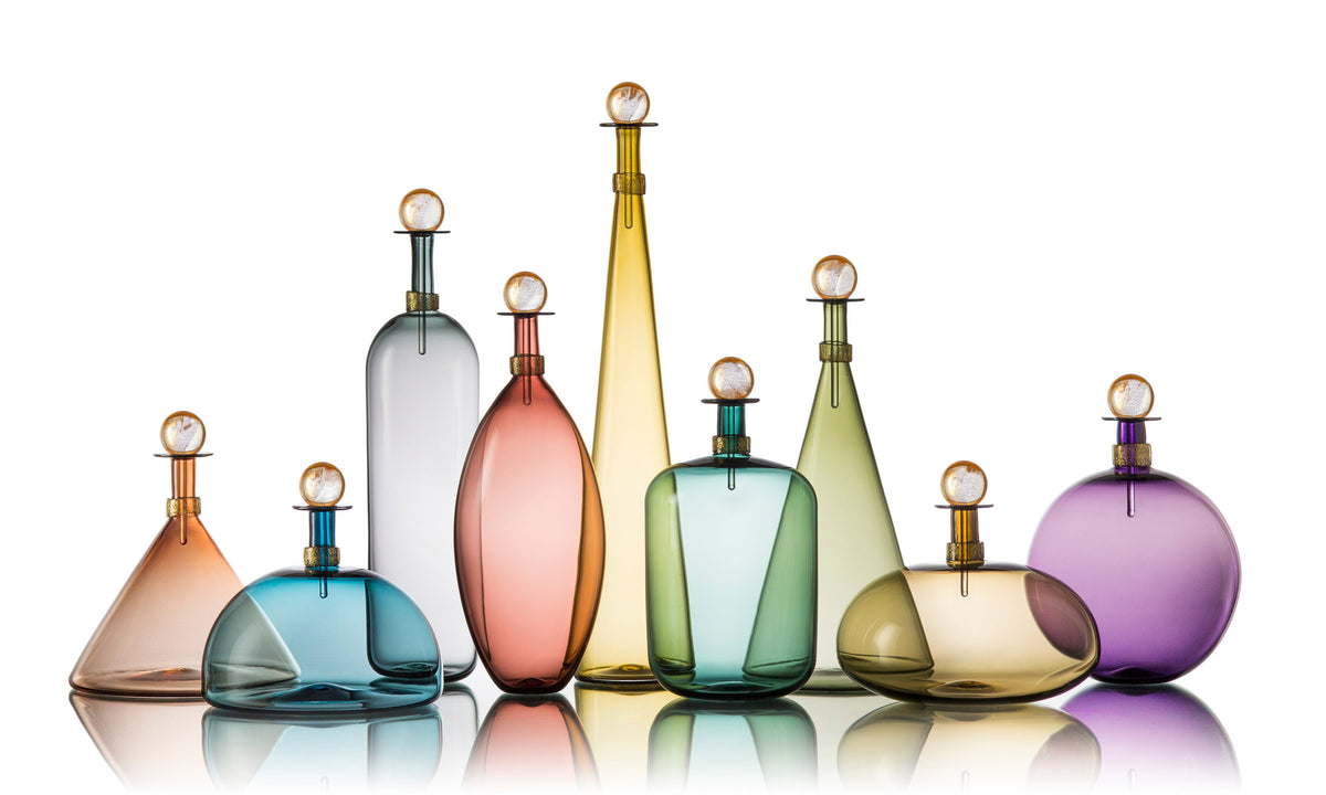left to right: short tea cone, mist dome, tall gray bottle, aubergine ellipse, tall straw cone, Tourmaline Jug, medium sage cone, Smoky Topaz Squat Orb, indigo sphere
