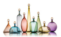 left to right: short tea cone, mist dome, tall gray bottle, aubergine ellipse, tall straw cone, Tourmaline Jug, medium sage cone, Smoky Topaz Squat Orb, indigo sphere