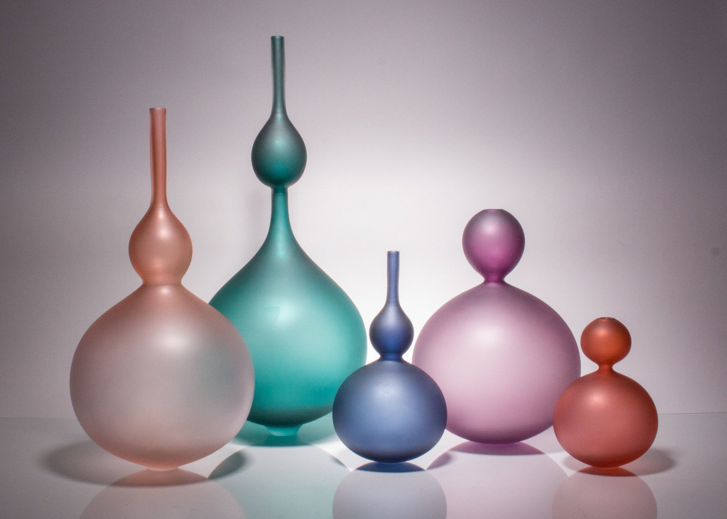 jewel tone set left to right: Large Rose Perle Bottle,  Jade Perle Double Bottle, Small Midnight Perle Bottle, Large Purple Perle, Small Red Perle