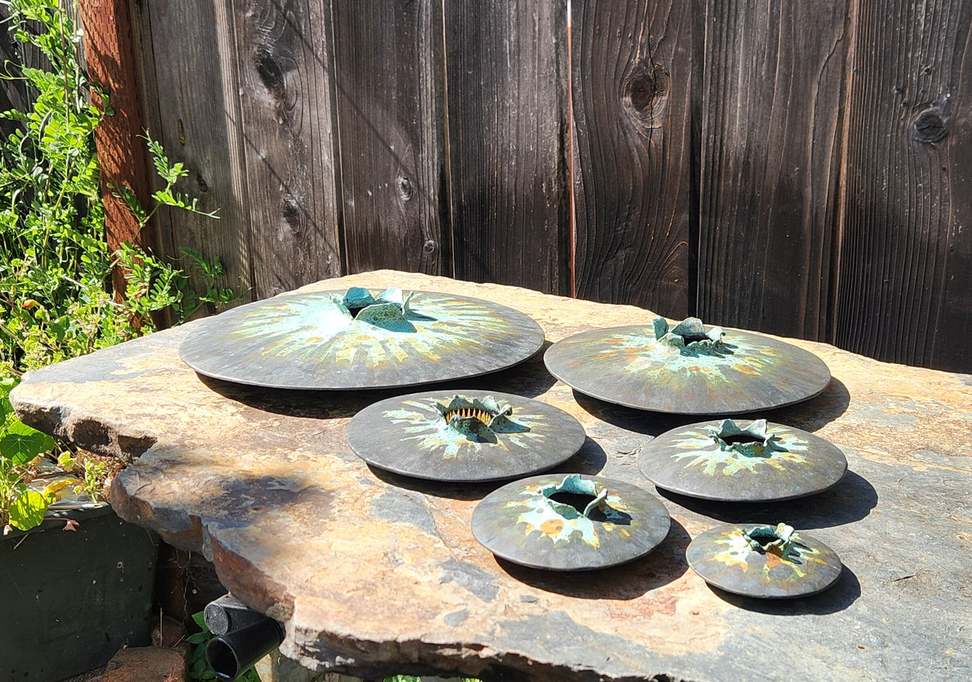 All six sizes of Lens vase in tricolor patina, low angle view.