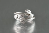 shown with the artist's triple leaf ring